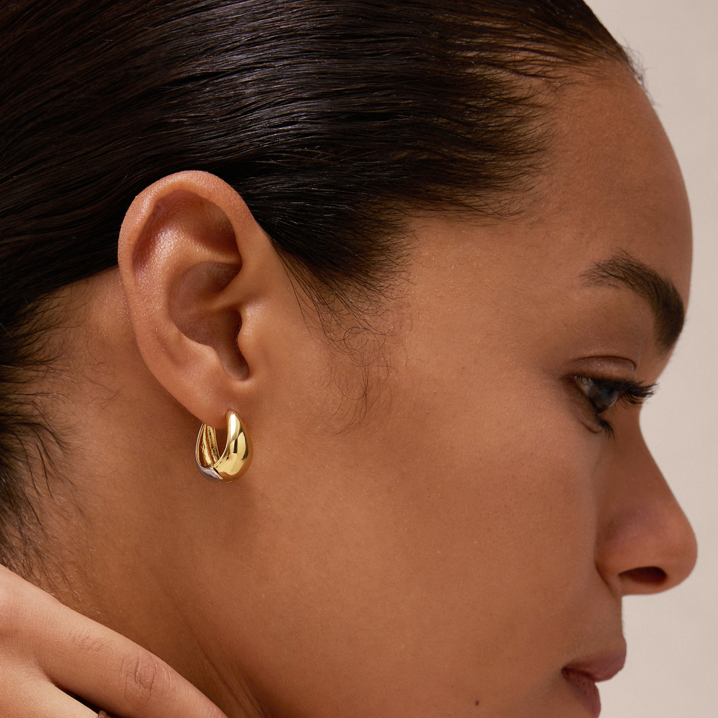 Two tone gold hoop earrings on black model