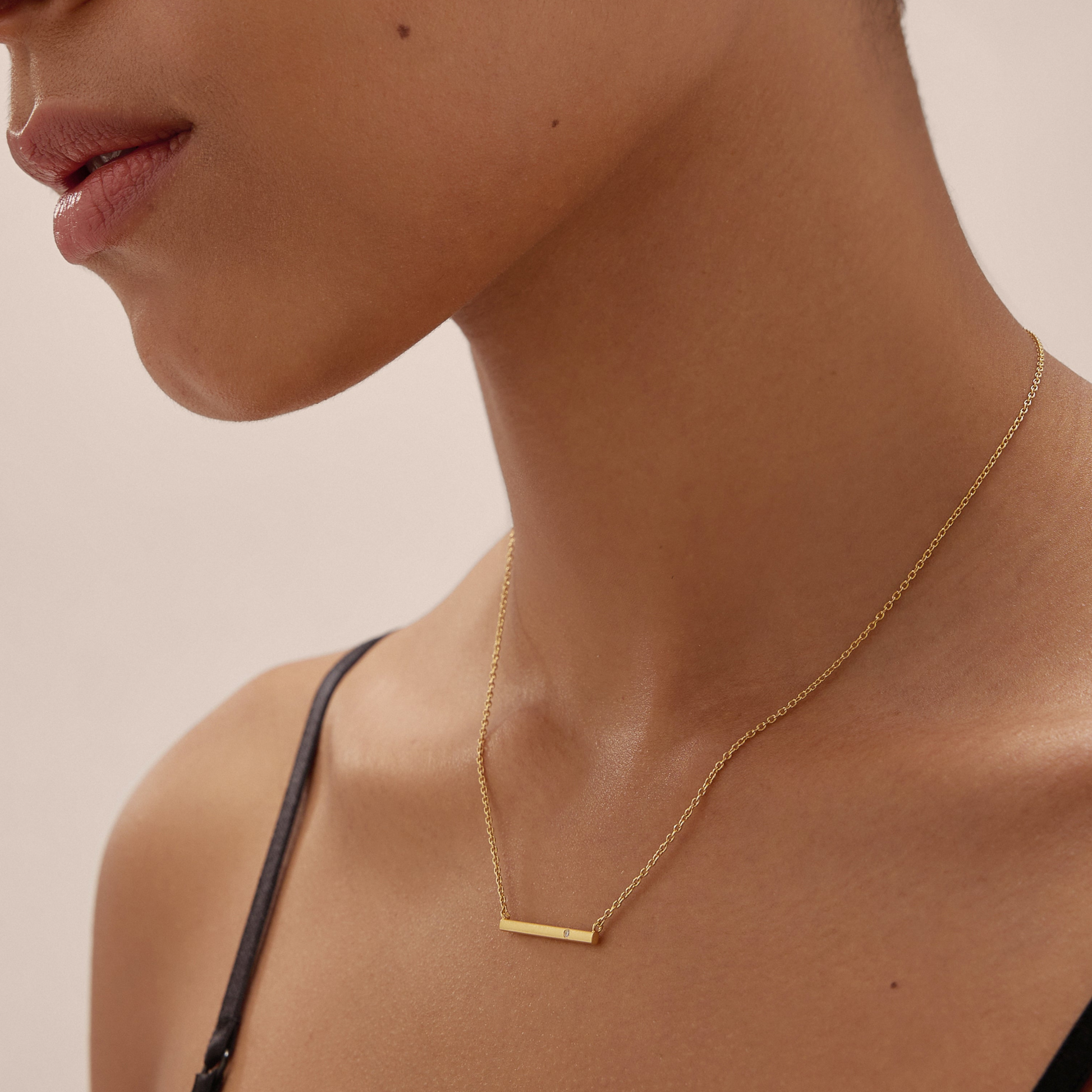 Womens gold bar necklace on black model